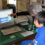 Christina Choi working with Korean kids boy at computer